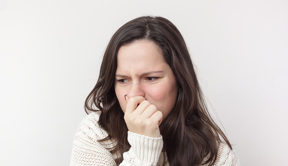 a woman holding her nose in response to a bad smell