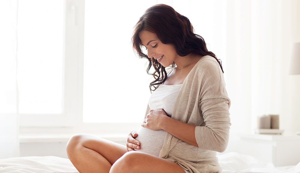 a pregnant woman holding her stomach