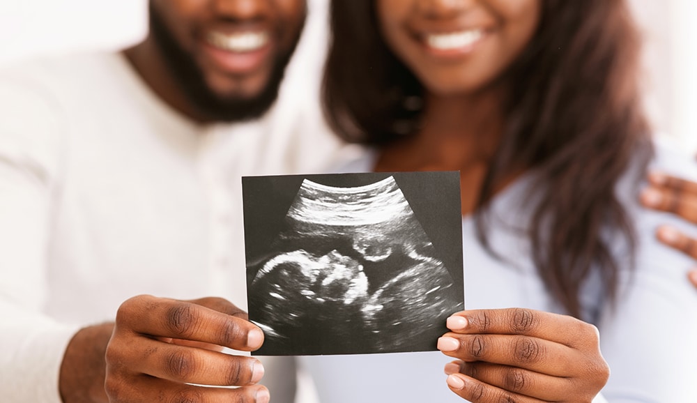 a couple holding up an ultrasound picture