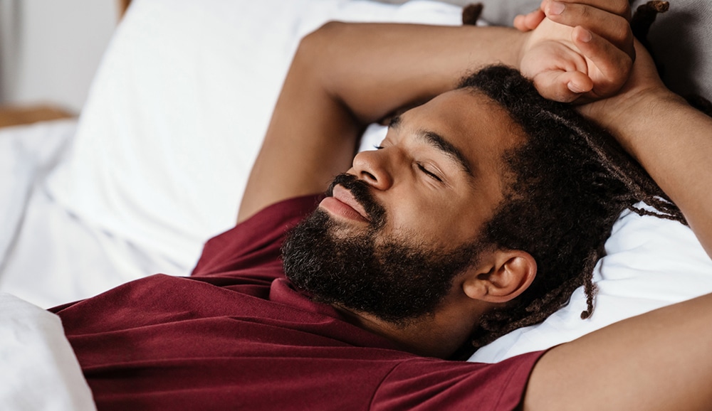 a man sleeping with his hands above his head