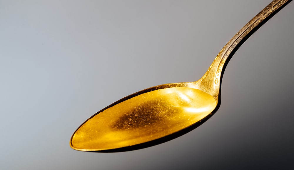 a spoon containing liquid fish oil, cod liver oil, or other fish oils