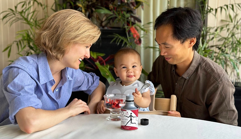 parents and a baby with a fish oil supplement